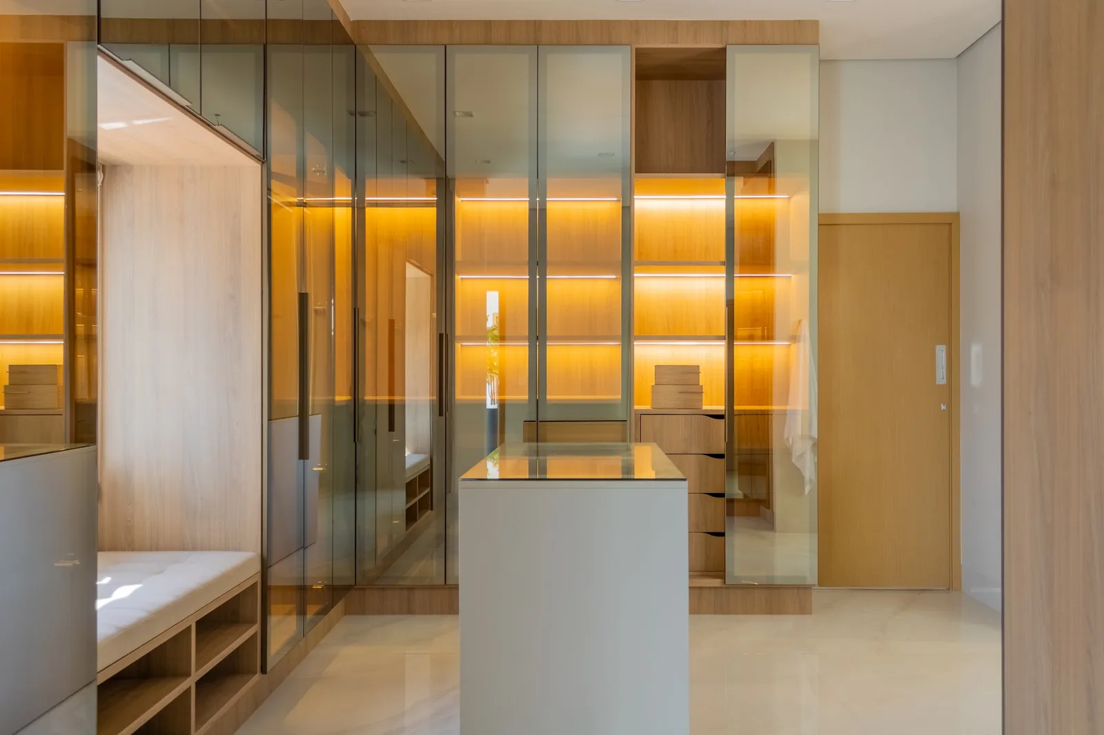 Closet planejado com ilha central e iluminação embutida