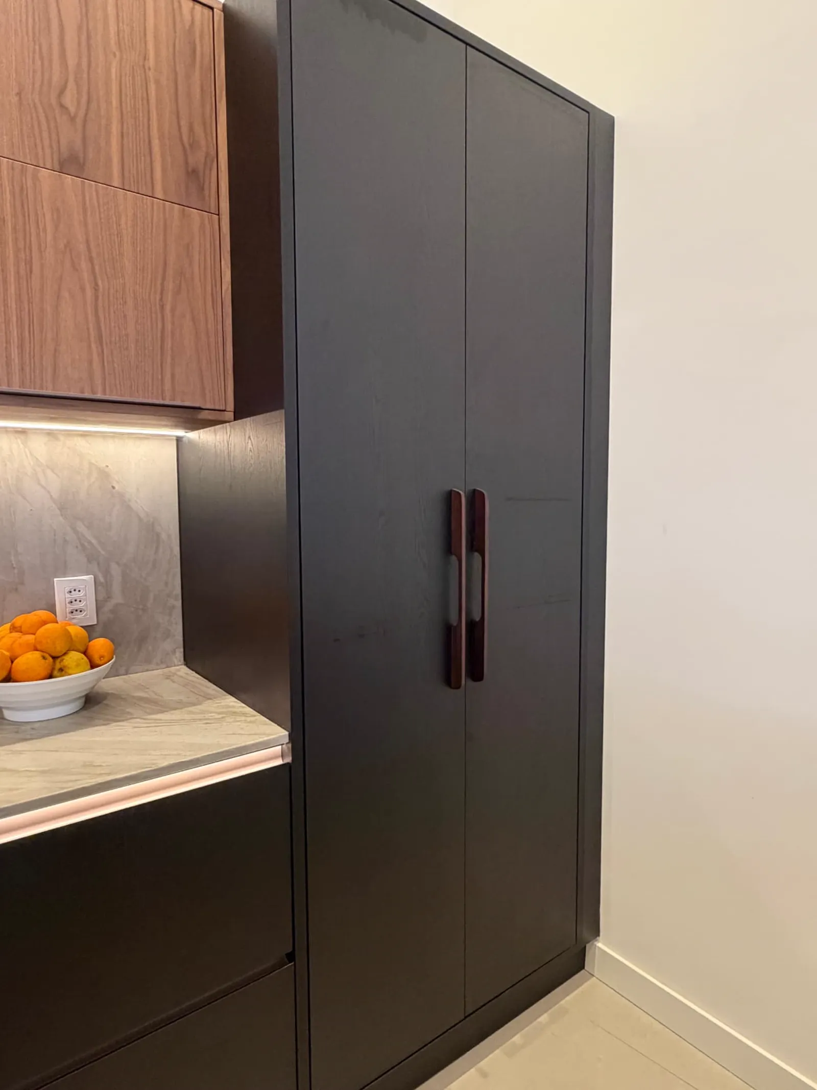 Detalhe de puxadores embutidos em marcenaria amadeirada no showroom